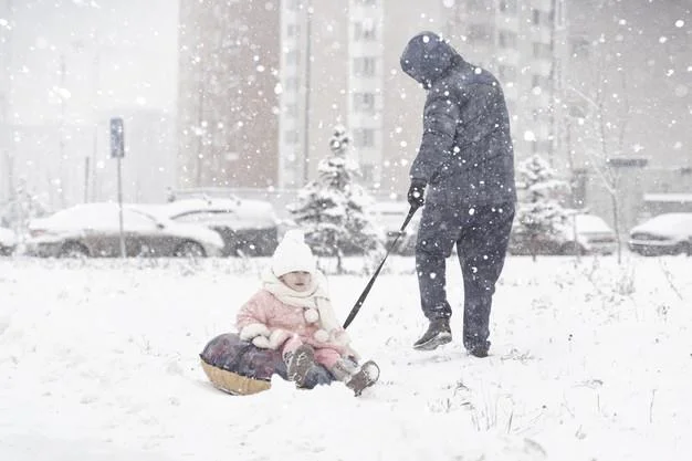Dad takes little daughter on a tubing in a strong snow storm Premium Photo
